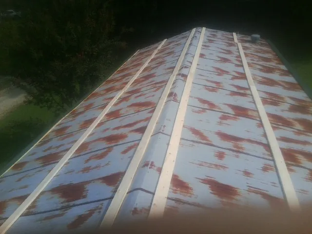 Rusted metal roof panels with new wood purlins before replacement — Storm Damage Roof Repair in Odenton by Roofing Brothers