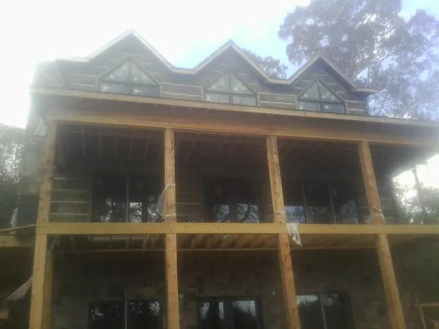Dormers and porch framing on a large log home under construction — Roof Coating work by our crew in Odenton