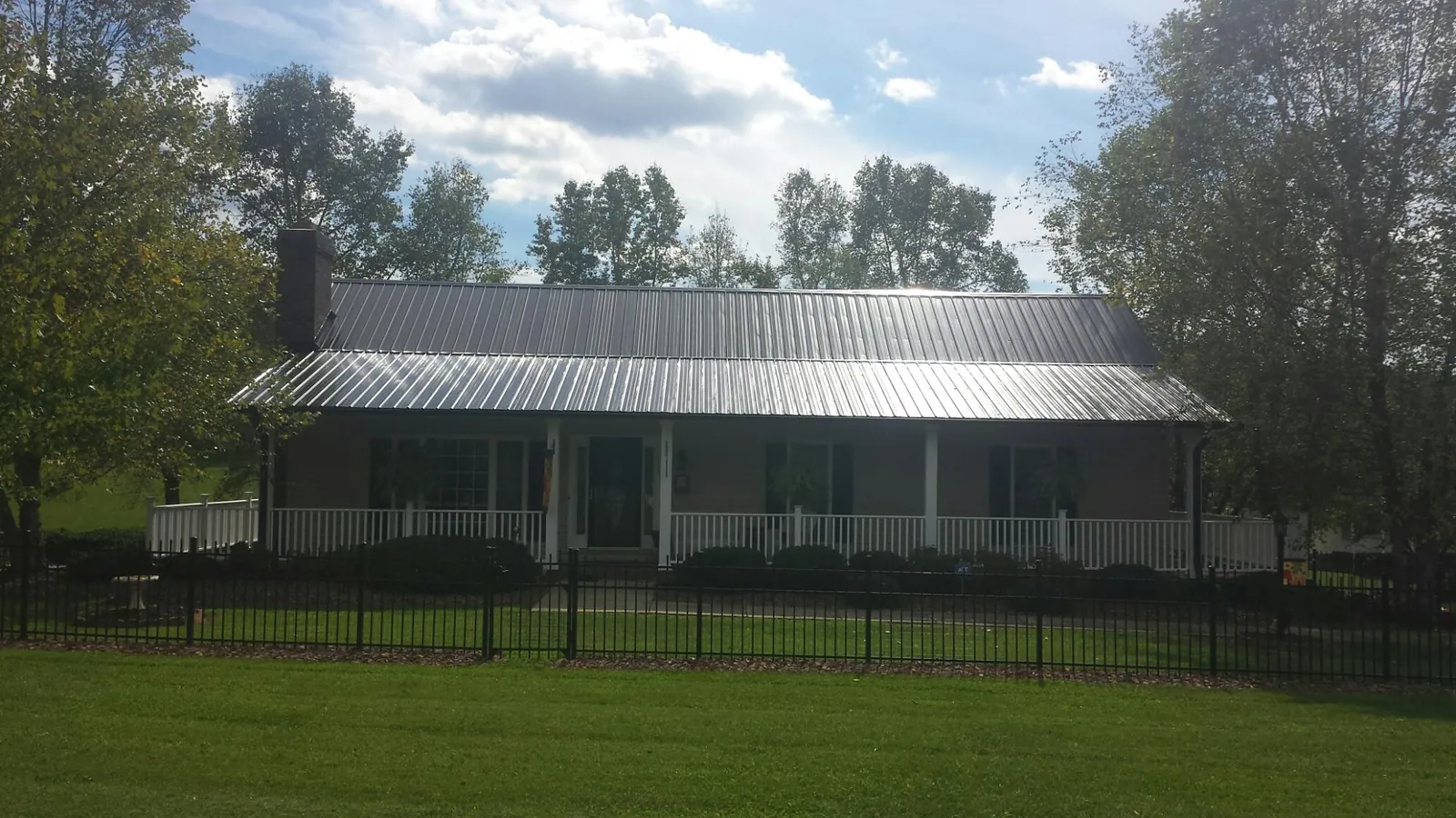 Gray metal roof on a brick ranch with a full width front porch — Gutter Guard Installation work by our crew in Odenton