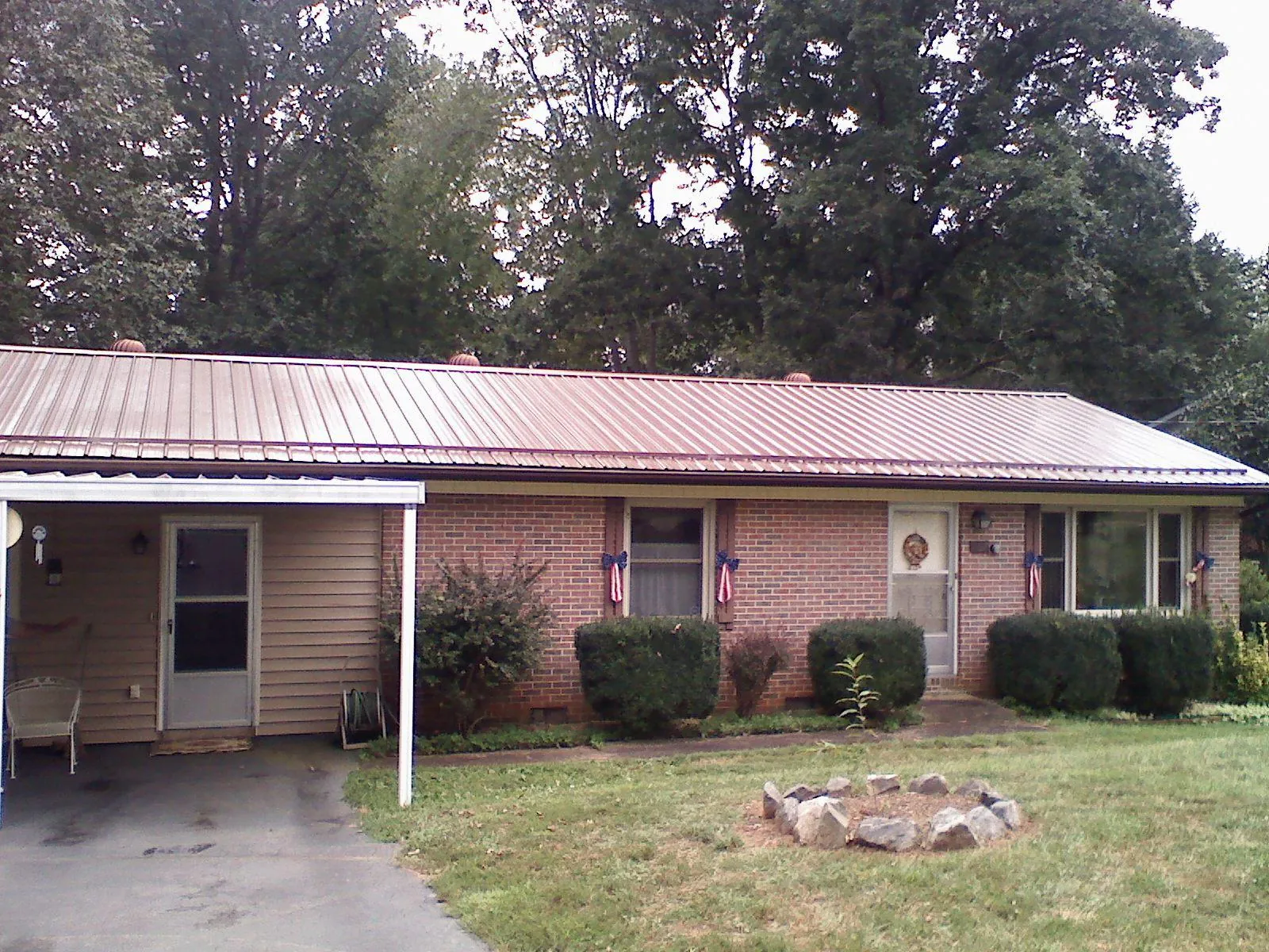 Bronze metal roof and carport on a brick ranch home — Roof Repair work by our crew in Odenton